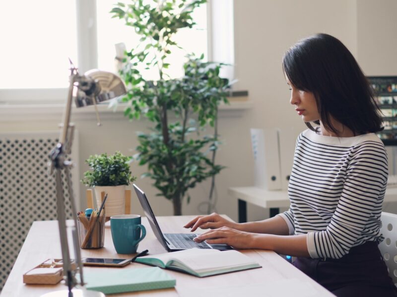 a woman sitting at a desk using a laptop computer