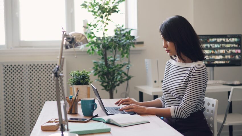 a woman sitting at a desk using a laptop computer