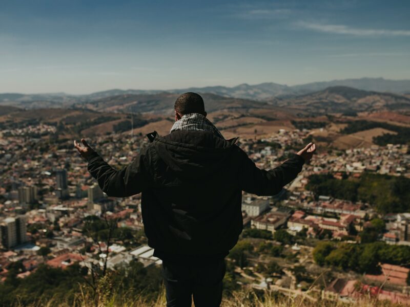 a man standing on top of a lush green hillside