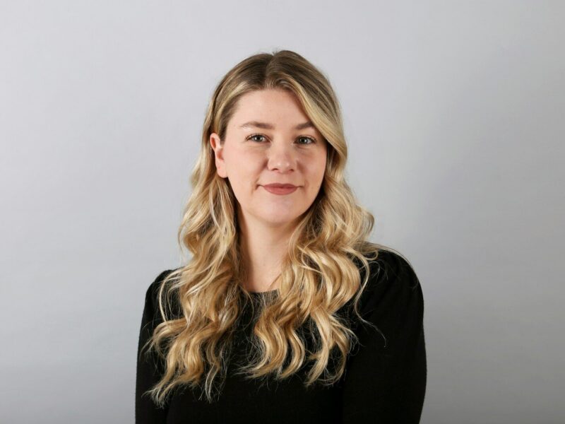 a woman with long blonde hair wearing a black shirt